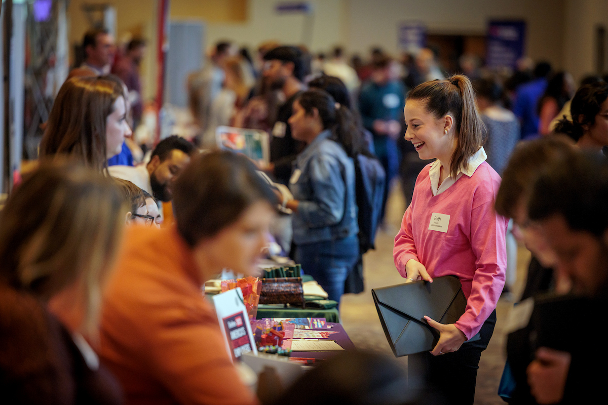 students speak with potential employers at the career expo