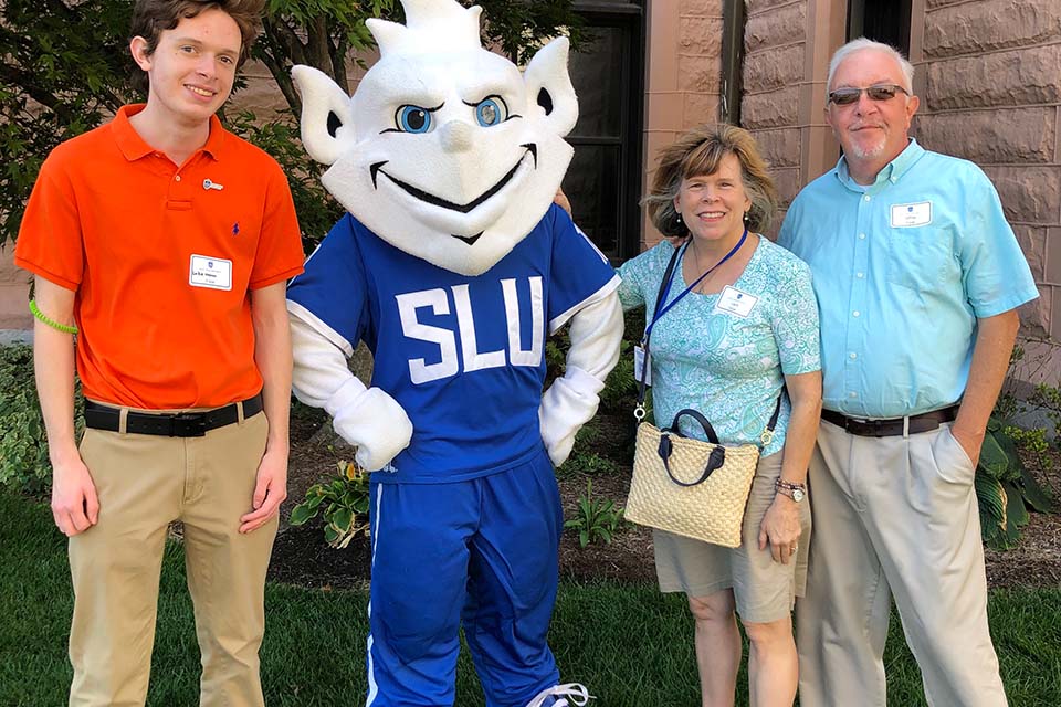 Three members of the Fister family pose with the Billiken.