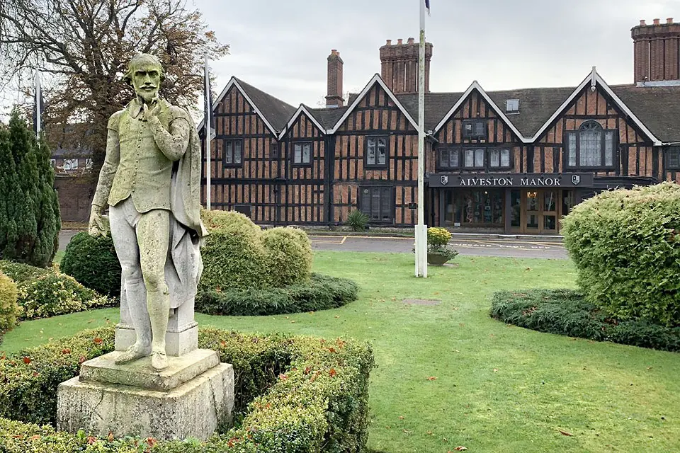 Exterior of a large brick building next to an elaborate garden