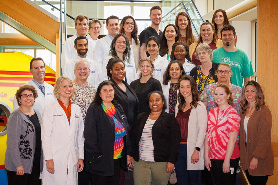 Group photo of entire Child Neuro Group standing in front of staircase. 