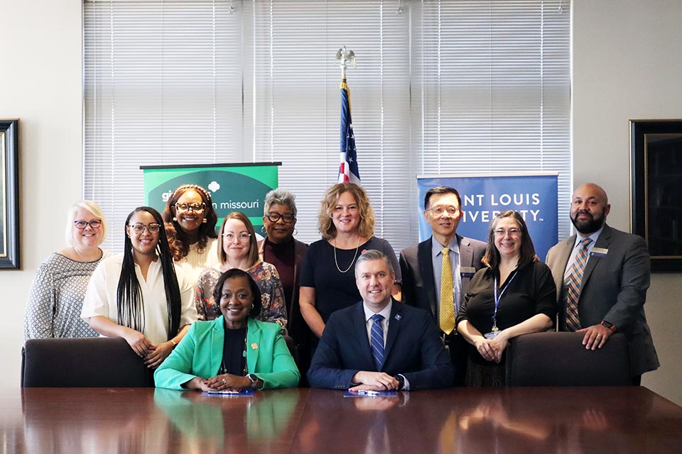 A group of people pose for a photo in a room.