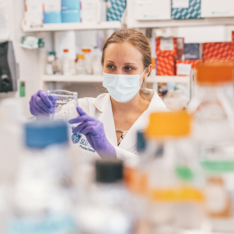 A scientists studies a sample in a lab