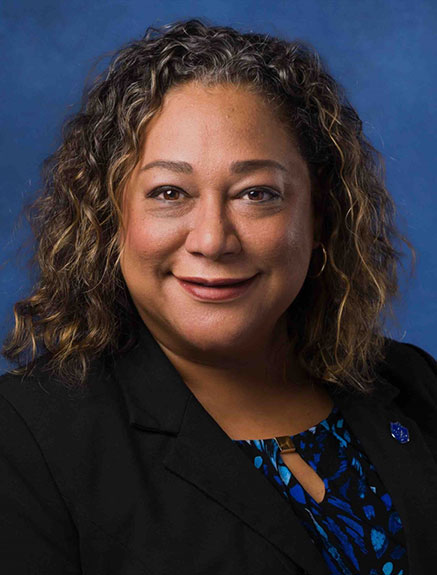 Smiling woman in black suit and blue shirt