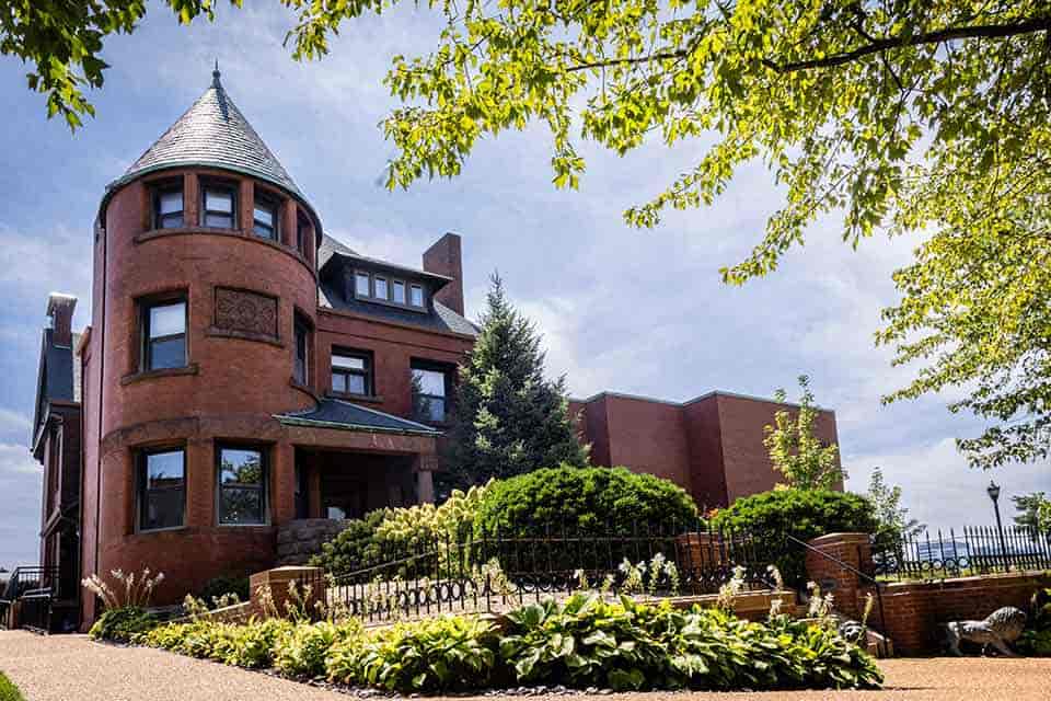 A large, three-story red brick building on a sunny day. 